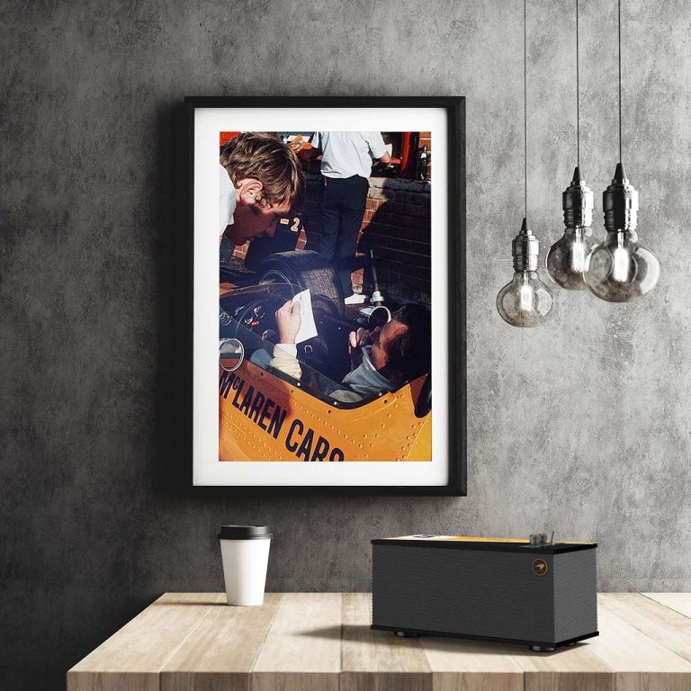 Klipsch The One McLaren Edition placed on a coffee table with a wall-hanging picture in the background
